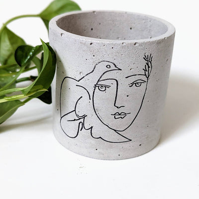 Picasso's dove and woman outline painted on a concrete planter