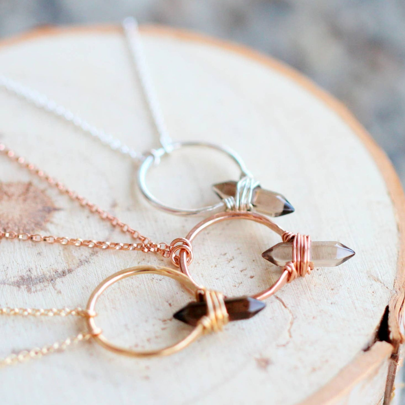 Several necklaces in silver, 14k gold and 14k rose gold with smokey quartz gemstone pendants