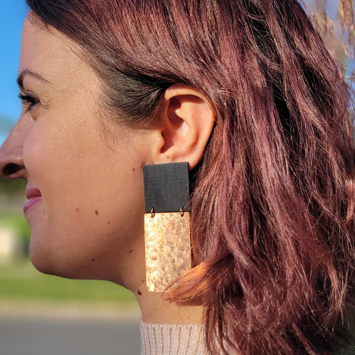 copper + black statement earrings on a model