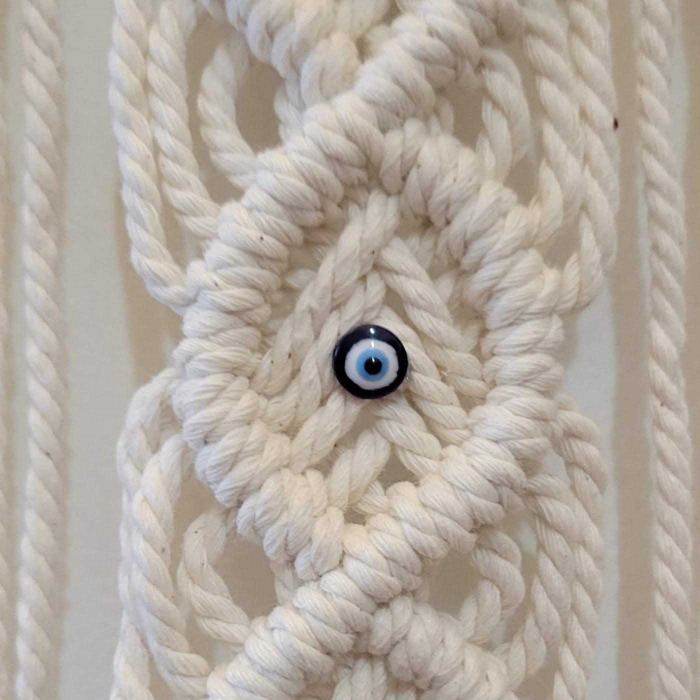 Macrame evil eye wall hanging, close up of pattern