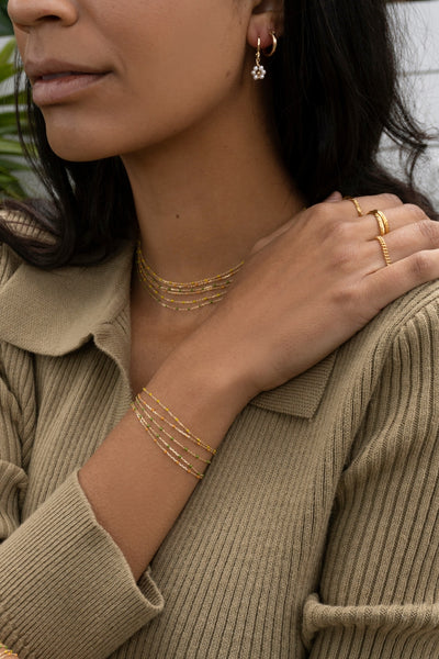 model wearing gold plated bracelet with blue enamel detail