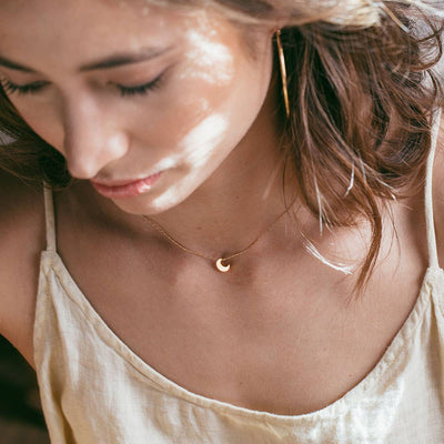 model wearing 14k plated gold crescent moon necklace
