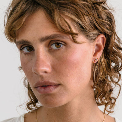 rainbow bar stud earrings in jewel tones on a model