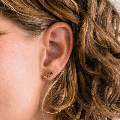 rainbow bar stud earrings in jewel tones on a model