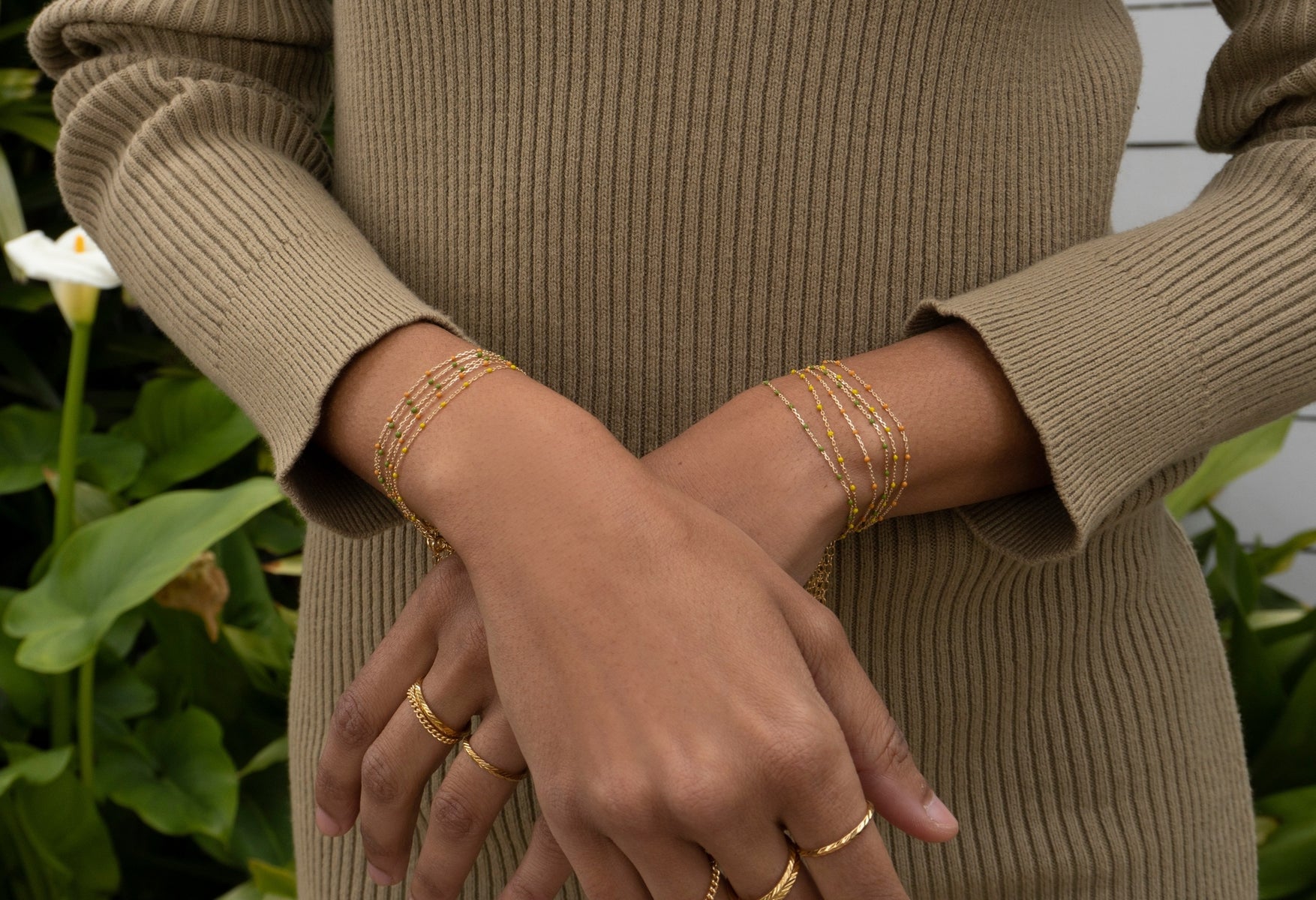 model wearing gold plated bracelet with blue enamel detail