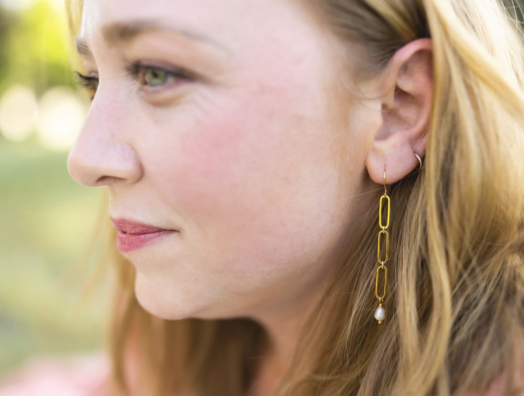 model wearing gold plated paper clip earrings with fresh water pearl