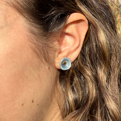 blue porcelain bowl stud earrings with gold centers on a model