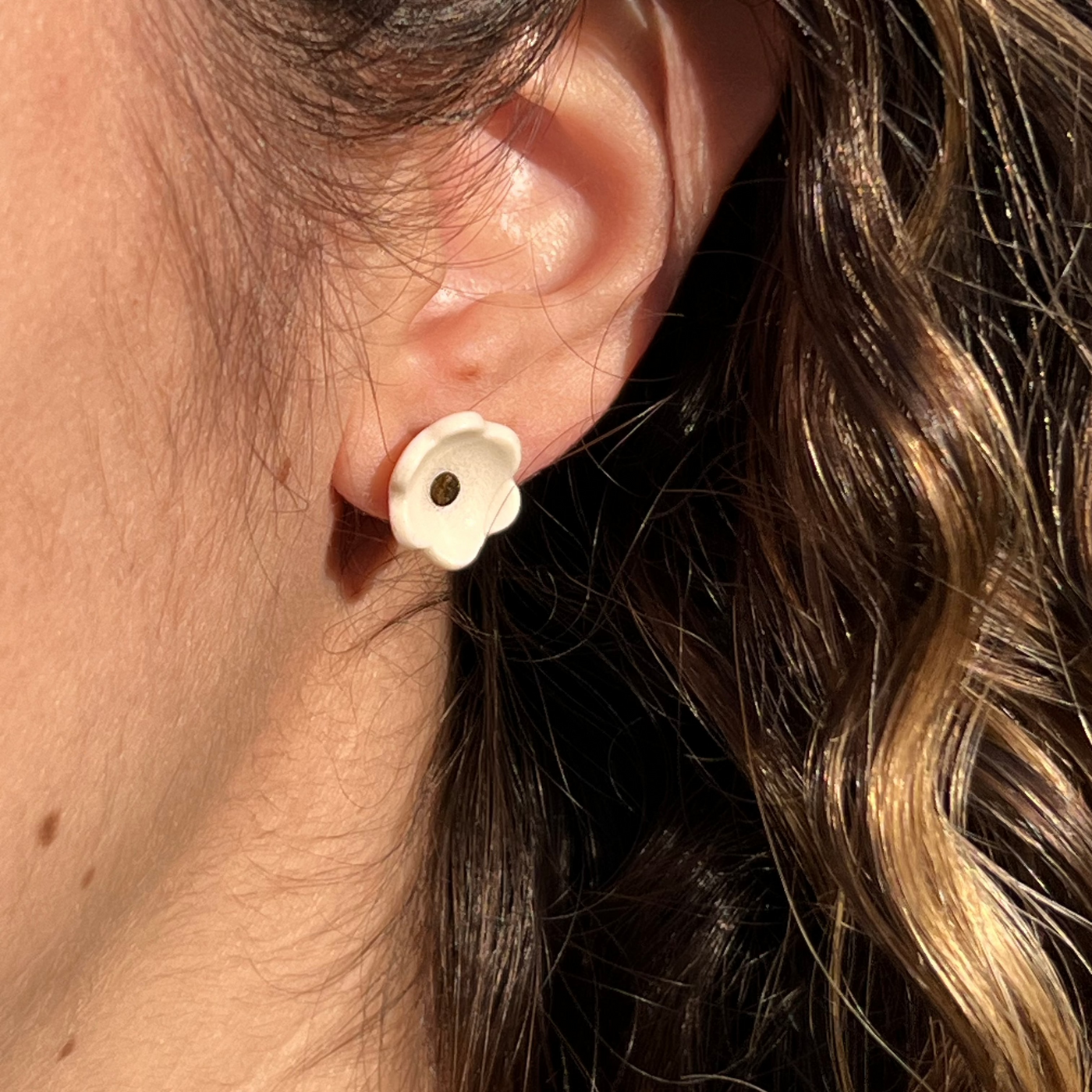 porcelain blossom stud earrings in white on a model