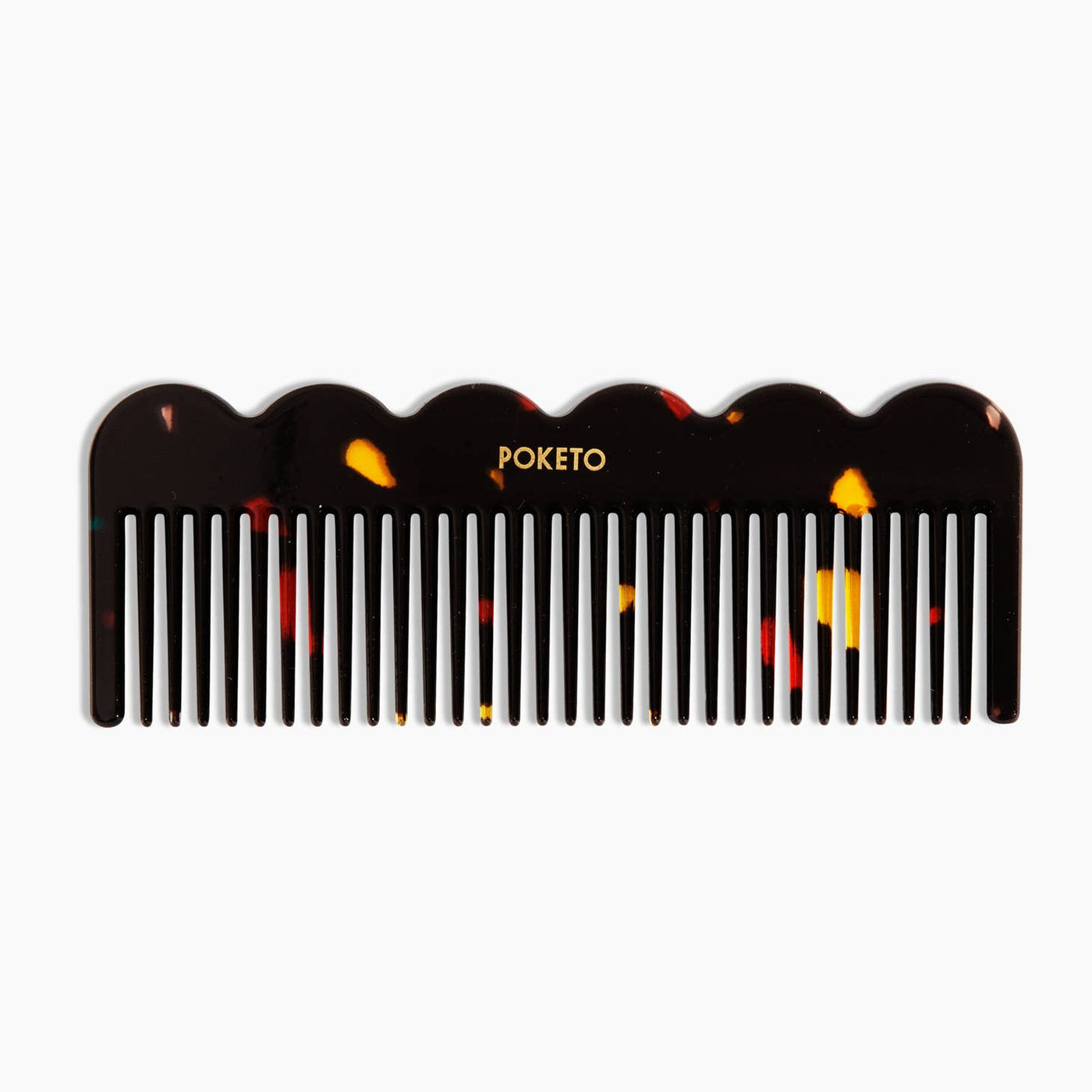 Tortoise shell comb with waves on the handle and Poketo printed in caps in gold in the center of the handle