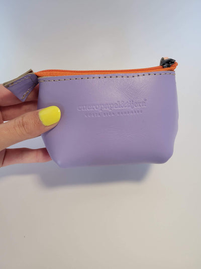 Model hand holding leather coin pouch in lavender with an orange zipper; coin pouch fits inside hand