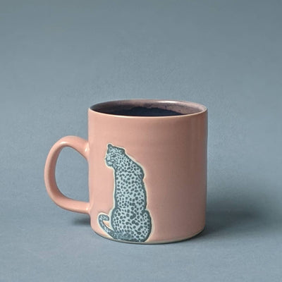 Pale pink mug with blue cheetah print; handcrafted