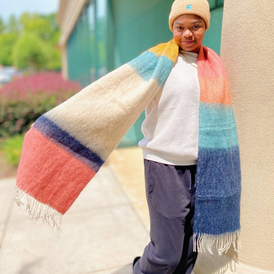 model wearing colorblock winter scarf with fringe in coral, yellow, blue and white