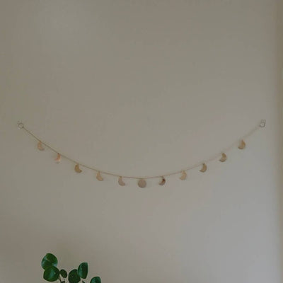horizontal hanging of moon phases wall garland with individual moons hand-cut and strung on brass chain