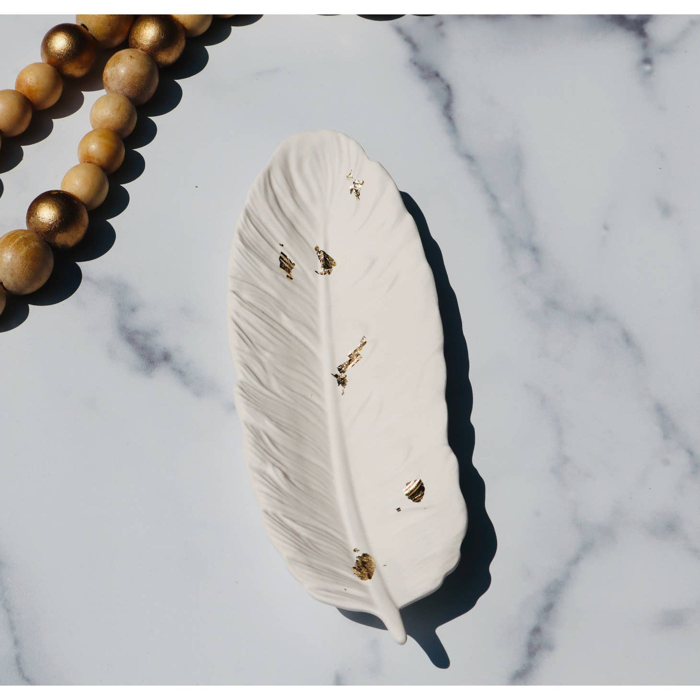 Jesmonite feather shaped tray in white with gold flecks