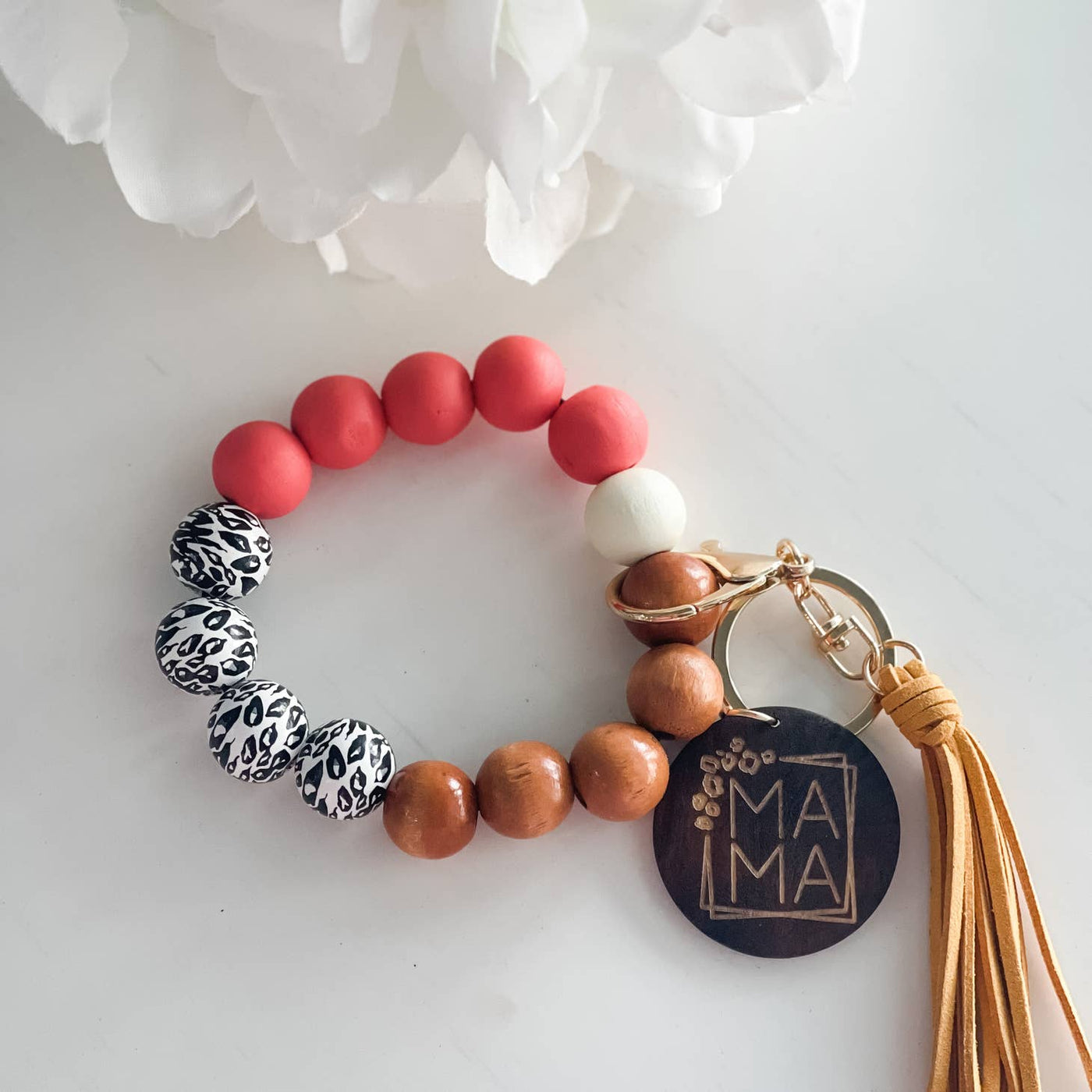 wooden beaded wristlet keychain with tassel and wooden disc that reads, "mama" colors are coral and brown and black and white leopard print