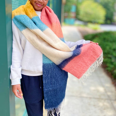 model wearing colorblock winter scarf with fringe in coral, yellow, blue and white