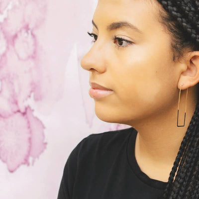 patina dipped brass square hoop earrings on a model