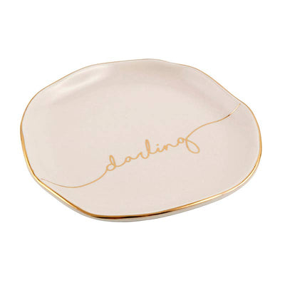 Side view of light pink circular trinket tray with gold trim and cursive "darling" printed in the center