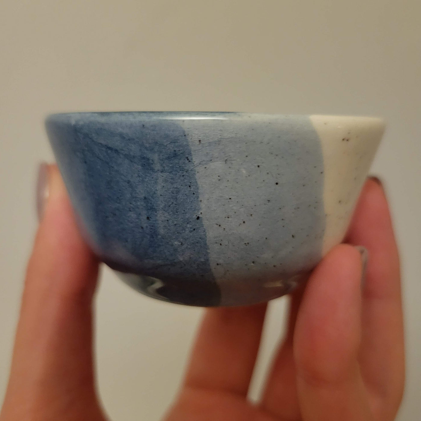 small ceramic ring dish glazed in shades of blue with speckles