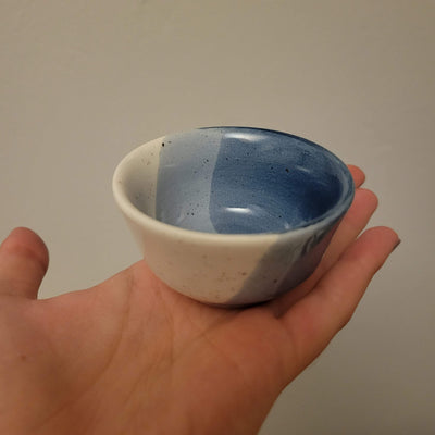 small ceramic ring dish glazed in shades of blue with speckles held in a hand