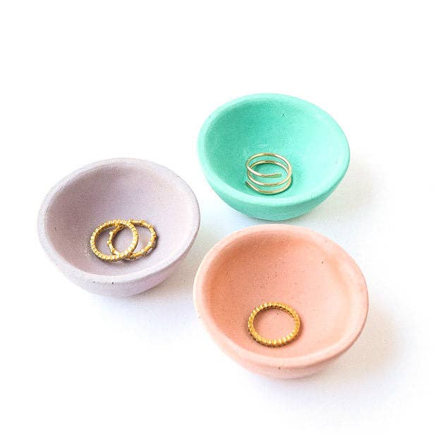 3 tiny round ring dishes with rings in them in various colors