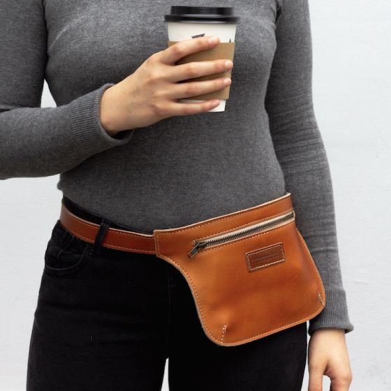 Model wearing camel color brown leather belt bag around her waist