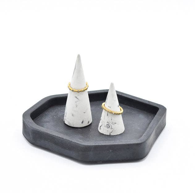 Small and large matching marble swirled ring cones with rings on them, sitting on top of a charcoal grey tray