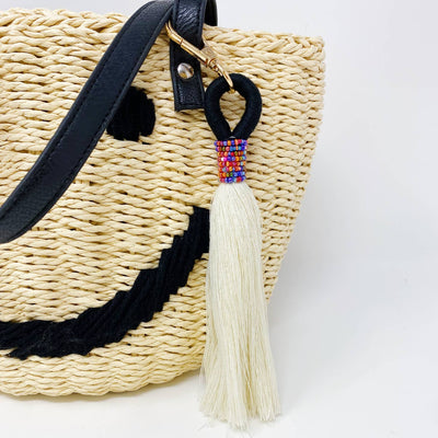 tassel keychain with rainbow beads hung on the strap of a bag