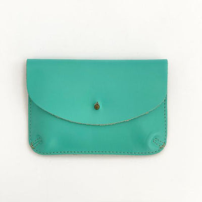 Front of an aqua color leather wallet, shaped like an envelope with a metal snap enclosure