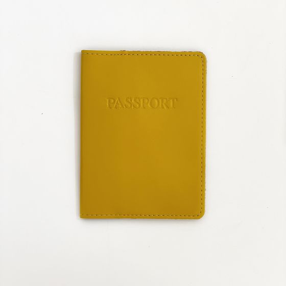 Front of mustard yellow passport case with "PASSPORT" engraved in all caps in the center top of the cover