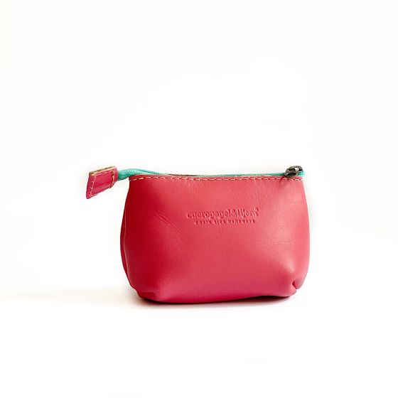 Leather coin pouch in hot pink with a turquoise zipper; logo of maker pressed into leather in front center
