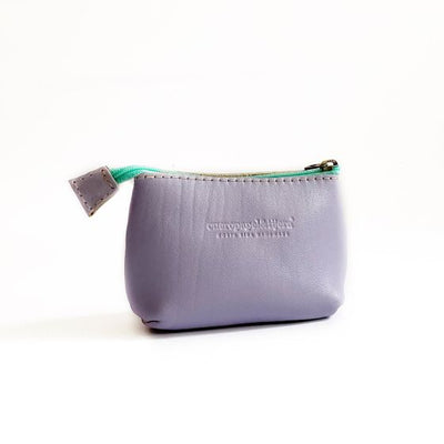 Leather coin pouch in lavender with a turquoise zipper; logo of maker pressed into leather in front center